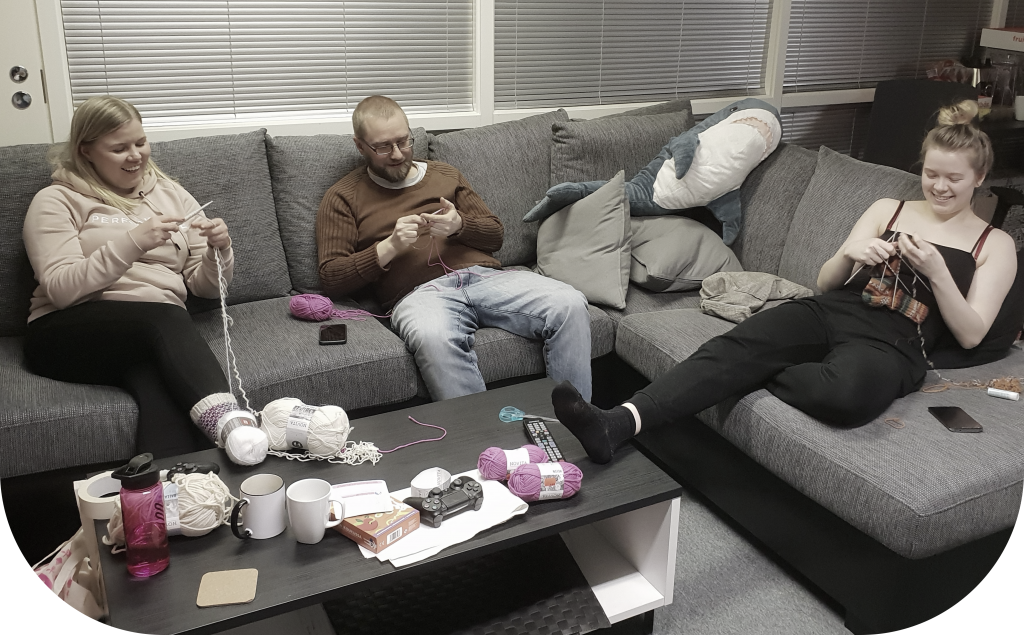 Team sitting on a sofa and knitting